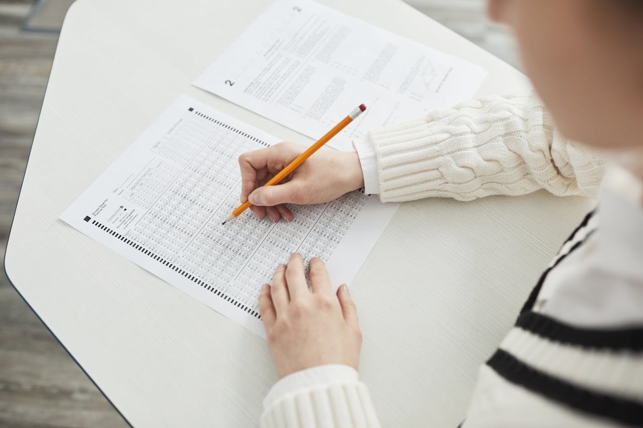 Close-up of a student filling out a multiple-choice exam in a quiet classroom setting.